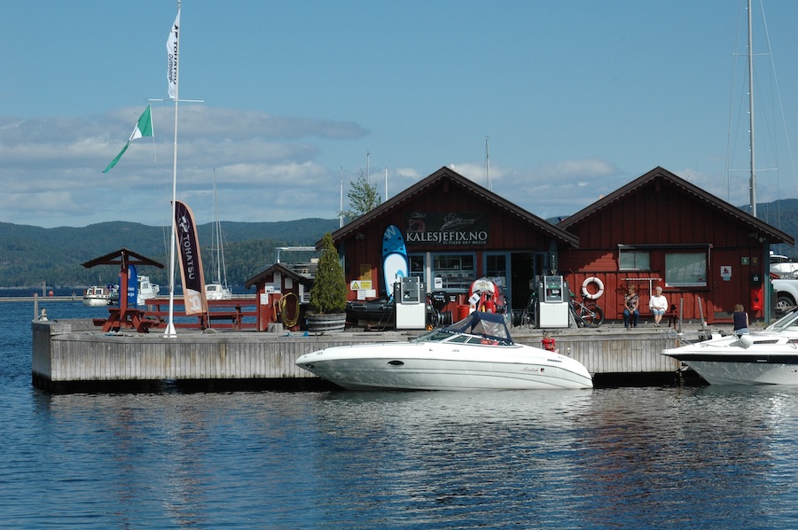 Hvit båt fortøyd til brygge