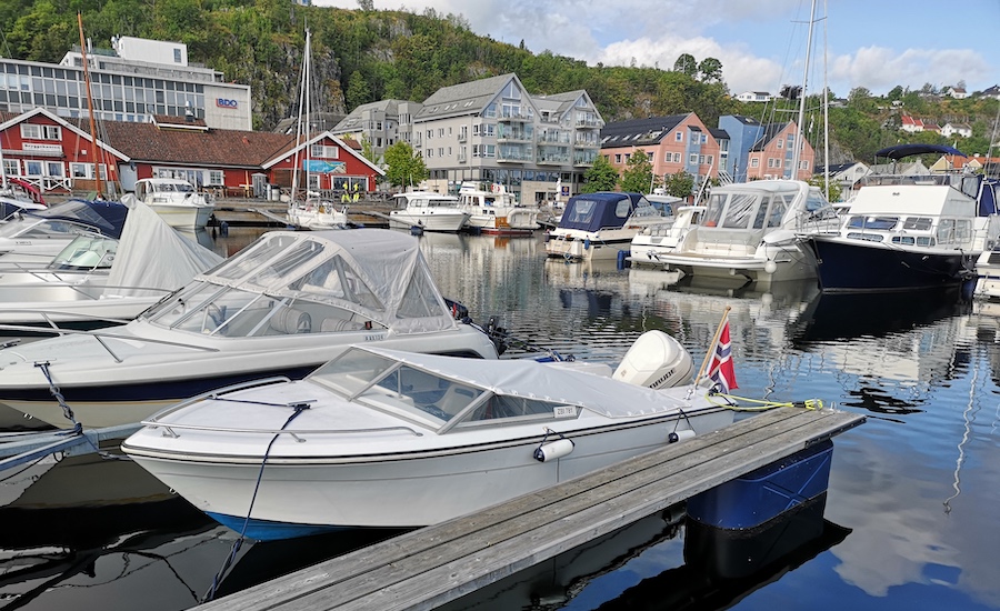 Hvite båter på en brygge med båtkalesjer