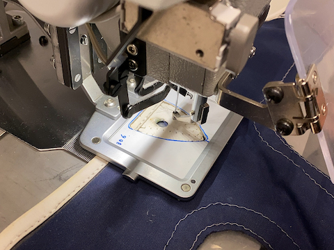 Blå kalesje som blir reparert med symaskin